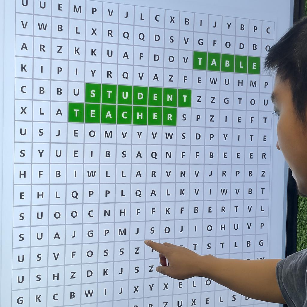 Guest playing interactive word search game at corporate event in Dubai, with branded screen, vibrant green backdrop