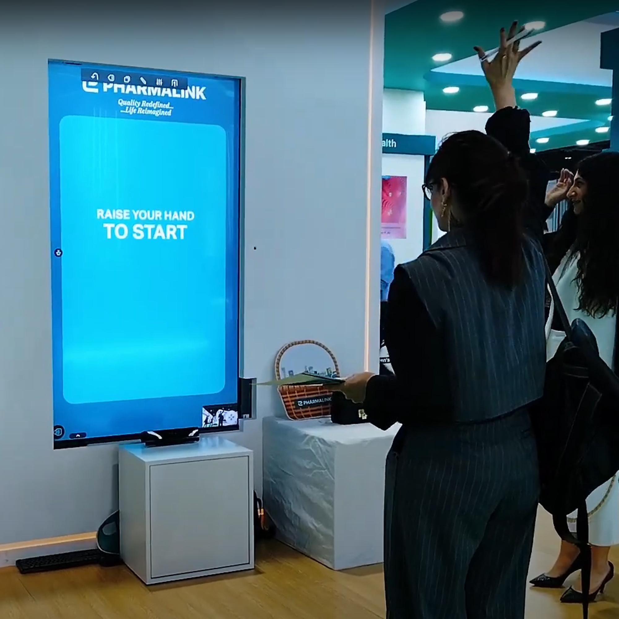 Player using body to slash branded items in a motion sensor game at exhibition in Dubai