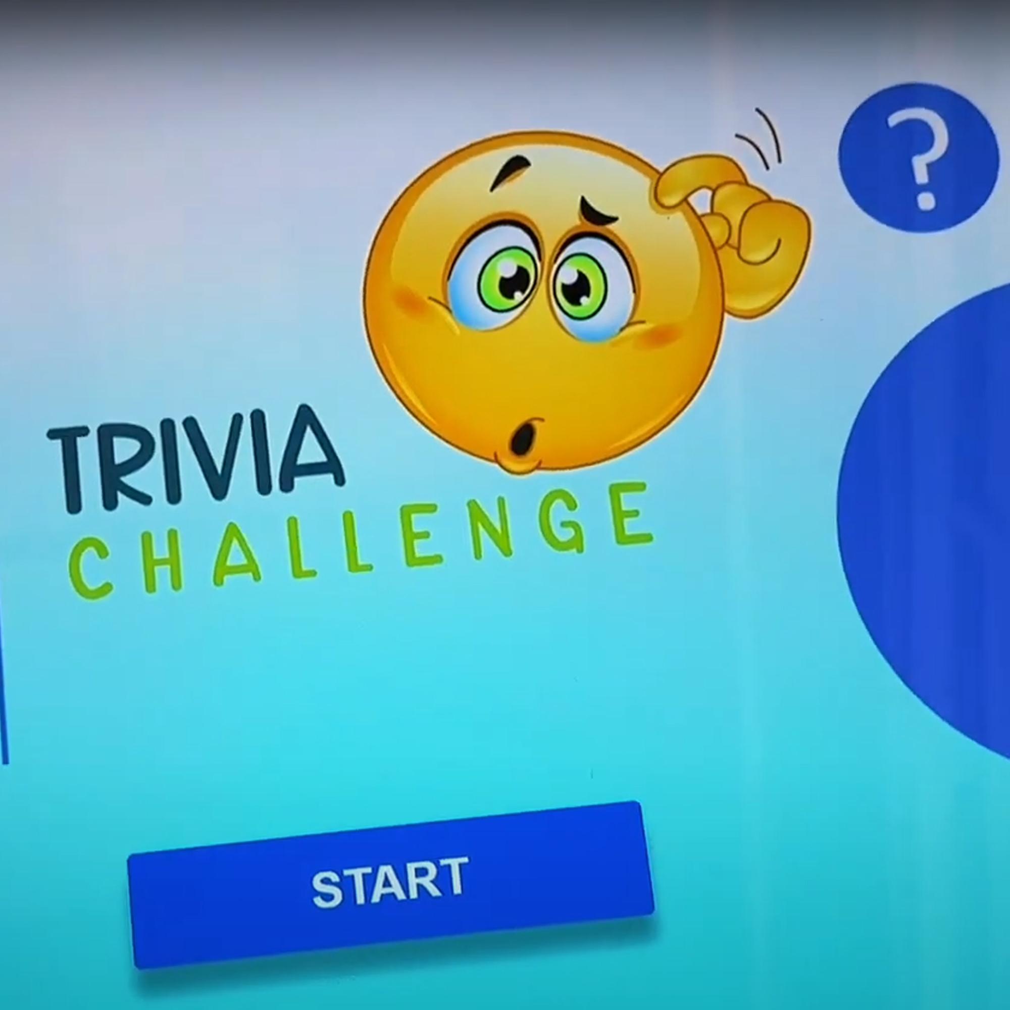 Touchscreen showing quiz results and a Dubai tower trivia question, with answer options and a person in a dark shirt standing beside the screen